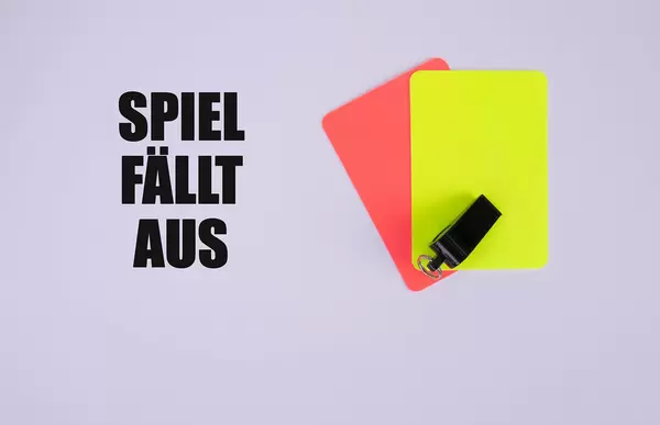 Red and yellow referee cards and a whistle for the referee and Spiel fällt aus text