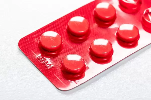 Red blister with pills on a white background