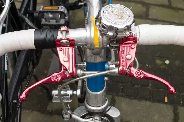 Red brake handles and bell on a racing cycle