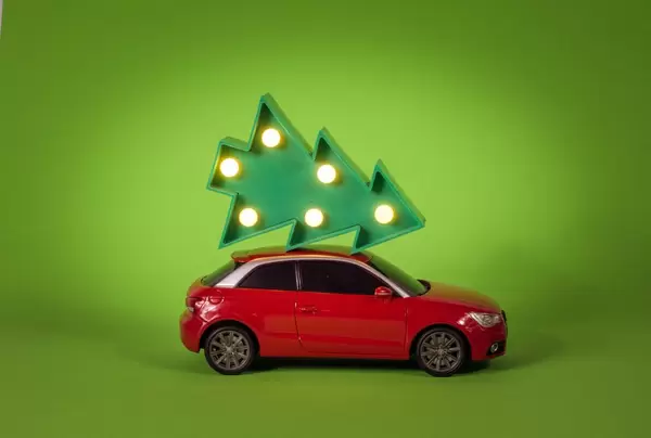 Red car carrying a Christmas tree
