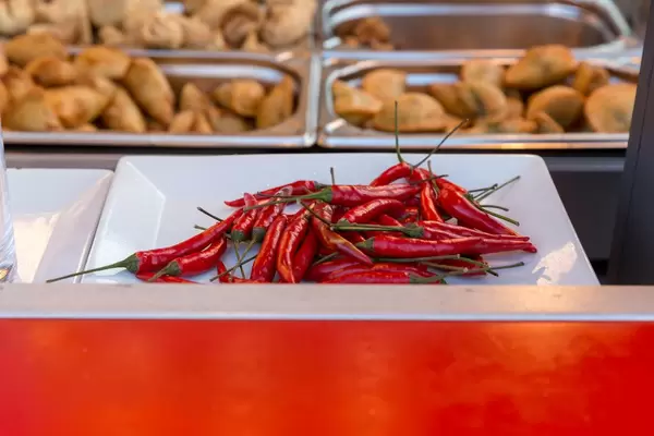 Red chilli peppers and chips in the blurry background