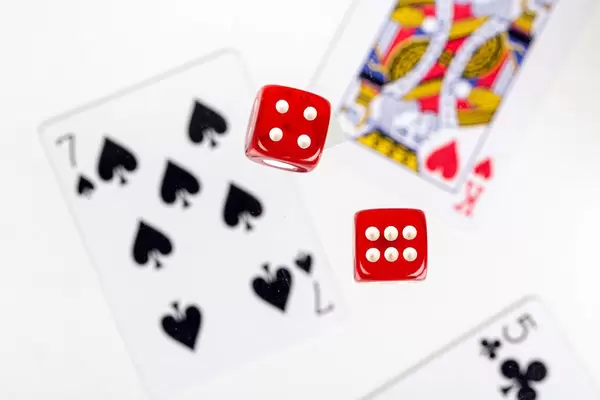 Red dice on a blurry background of playing cards