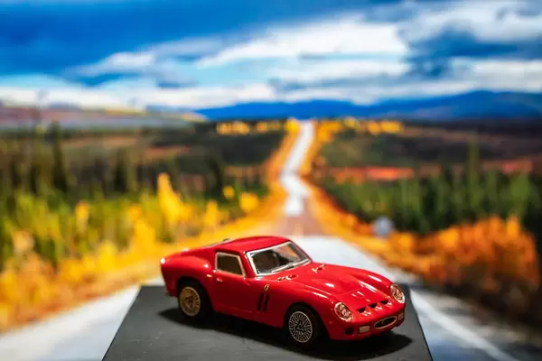 Red Ferrari toy car on platform with scenery background (Flip 2019)