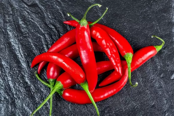 Red fresh chili pepper on a black background