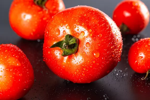 Red fresh tomatoes on a dark background