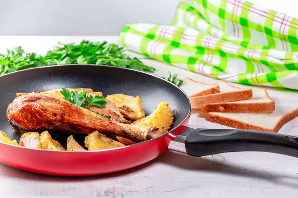Red frying pan with cooked food