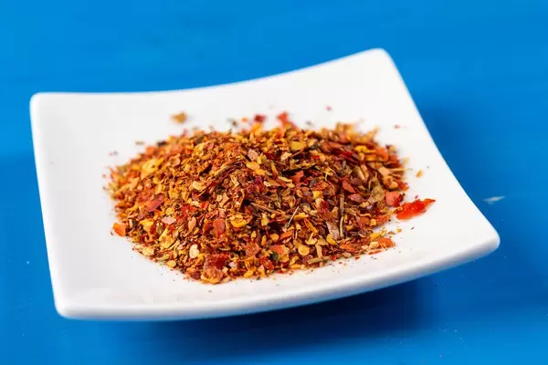 Red Grated Chilly Pepper on the white plate (Flip 2019)