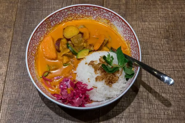 Red Hot Chili Curry: Geschmortes Rindfleisch mit Süßkartoffeln, Zucchini, Rotkohl, Röstzwiebeln und Jasmin-Duftreis im coa - Restaurant Köln