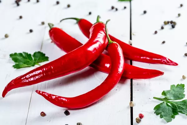 Red hot chili peppers on white wooden background  Flip 2019