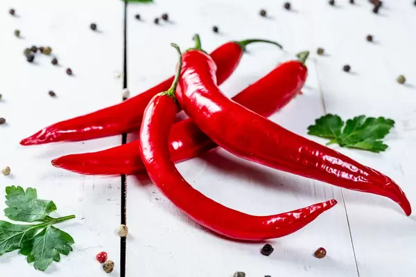 Red hot chili peppers on white wooden background