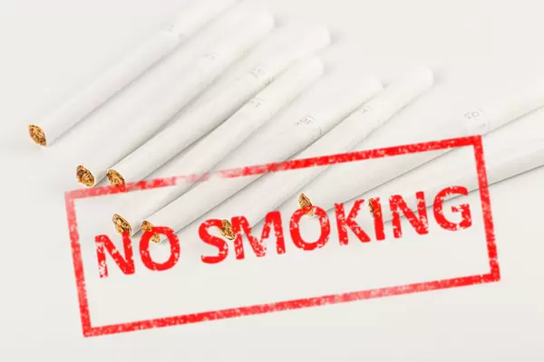 Red inscription no smoking on a white background with cigarettes