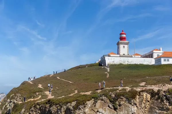 Red Lighthouse with Tourists at the Cabo da Roca coast in Portugal