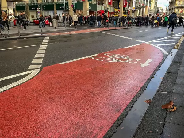 Red marked bike path leads from one side of the road to the other