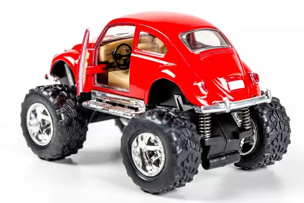 Red metal model of a Volkswagen car with large wheels and an open door