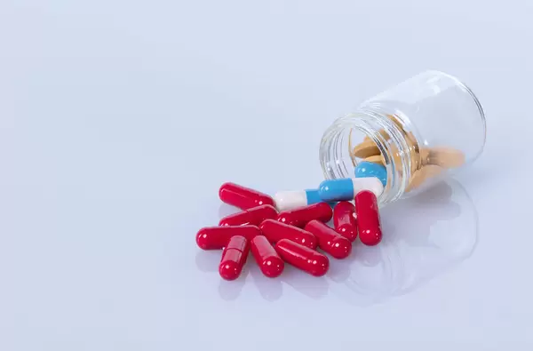 Red pills spilling out of a bottle