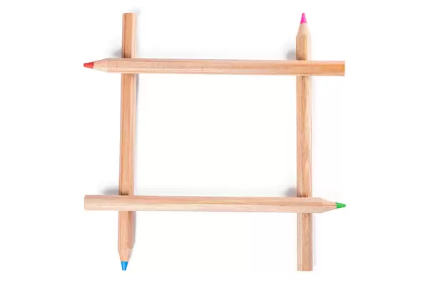 Red, pink, green and blue pencils stacked on a white background