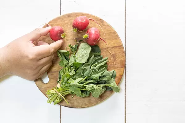 Red Radishes on the wooden cutting board with copy space