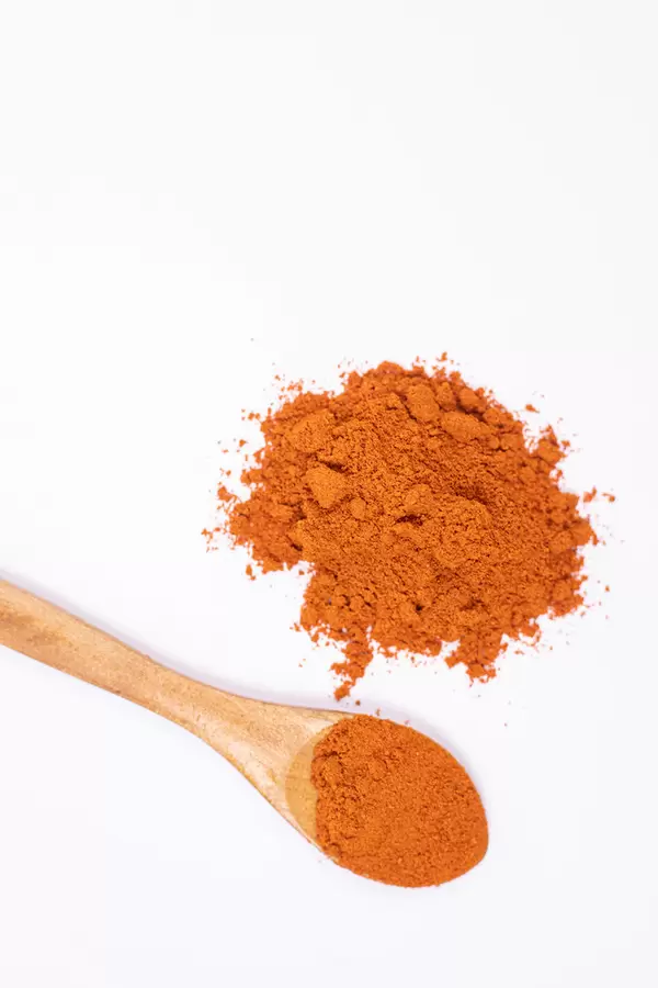Red spicy Paprika powder and wooden spoon with copy space