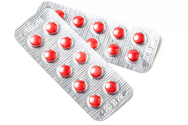 Red tablets in blisters on a white background