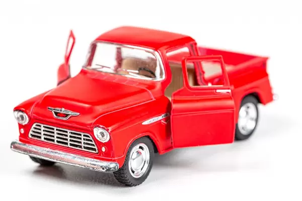 Red toy metal pickup truck with open doors