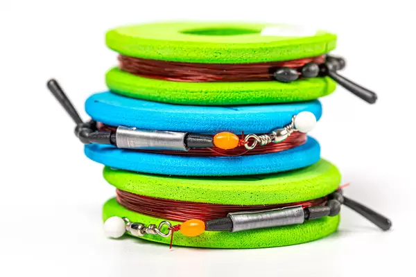 Reels with fishing gear on white, close-up