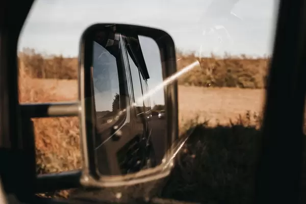 Reflection in the side mirror of bus. Road trip