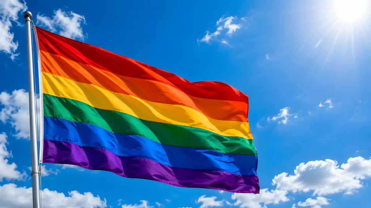 Regenbogenfahne weht stolz vor blauem Himmel