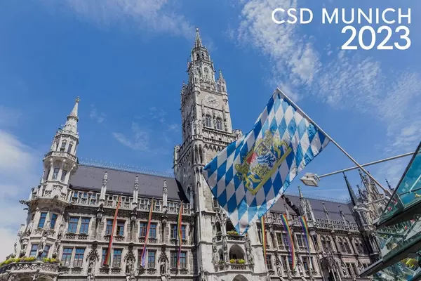 Regenbogenfahnen am Rand der Christopher-Street-Day Parade und dem Bildtitel CSD Munich 2023