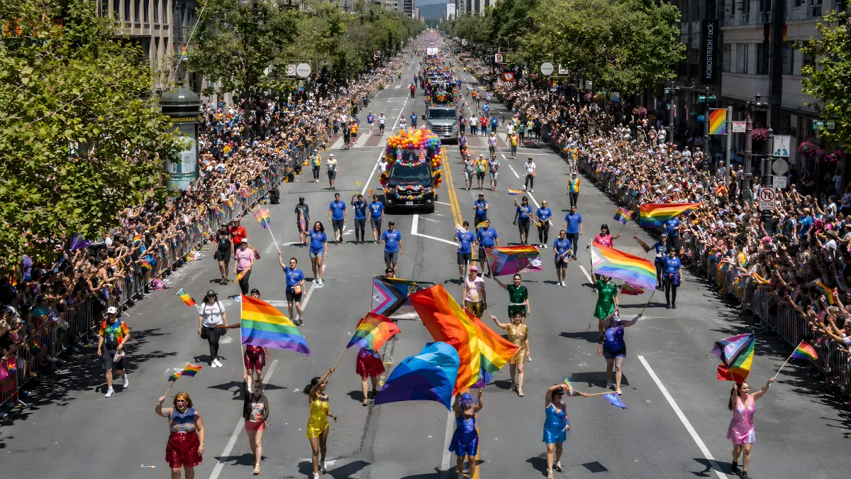 Regenbogenfahnen bei einer großen Pride-Parade in der Stadt — Bild kostenlos herunterladen