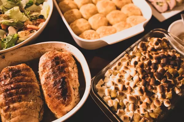 Reiche Auswahl an Speisen in Auflaufformen für das Thanksgiving-Essen mit Truthahn, mit Marshmallows überbackenes Gemüse und gemischtem Salat