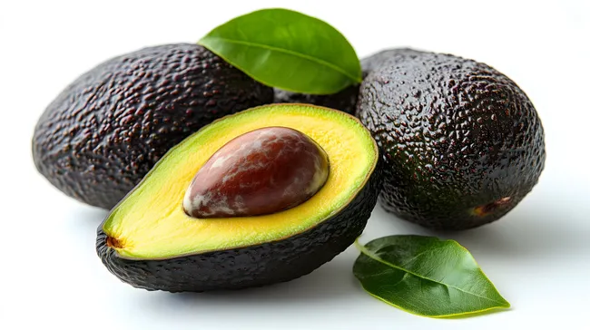 Reife Avocado mit Blättern auf weißem Hintergrund