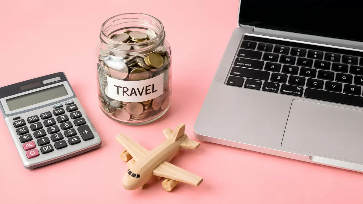 Reisesparkasse mit Münzglas, Taschenrechner und Laptop