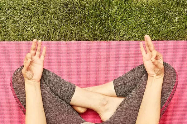 Relaxed woman meditating in yoga pose outdoors