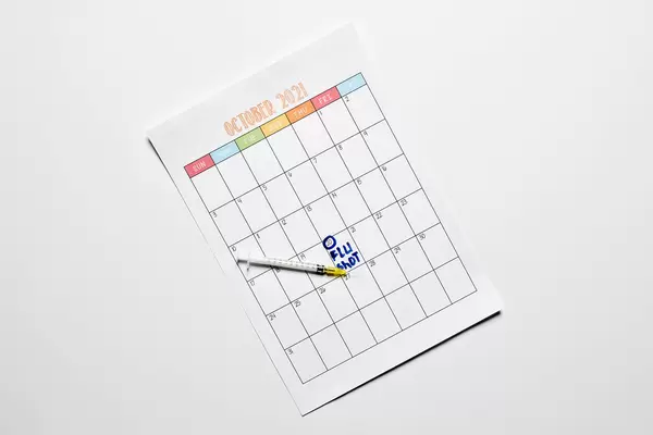 Reminder about taking flu vaccine on the calendar with a syringe