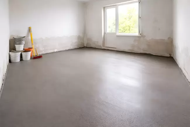 Renovierung eines Zimmers mit grauem Betonboden