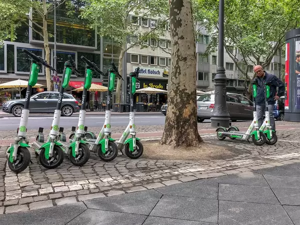 Rentable E-scooter by Lime at the roadside in Cologne to move car-free through the city