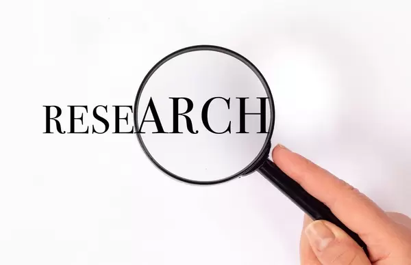 Research unter der Lupe auf weißem Hintergrund