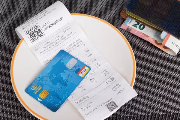 Restaurant bill, wallet and credit card on table