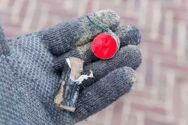 Reste von abgebranntem Neujahrs-Feuerwerk auf Hand in Handschuh