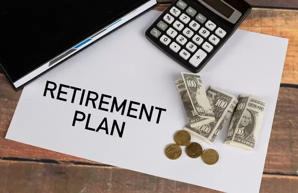 Retirement plan written on a paper with money and calculator