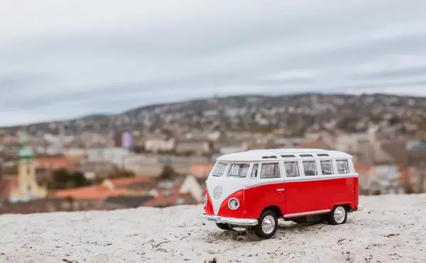 Retro-Spielzeugauto von VW auf der Mauer der Burg von Buda, im Hintergrund Budapest in Unschärfe