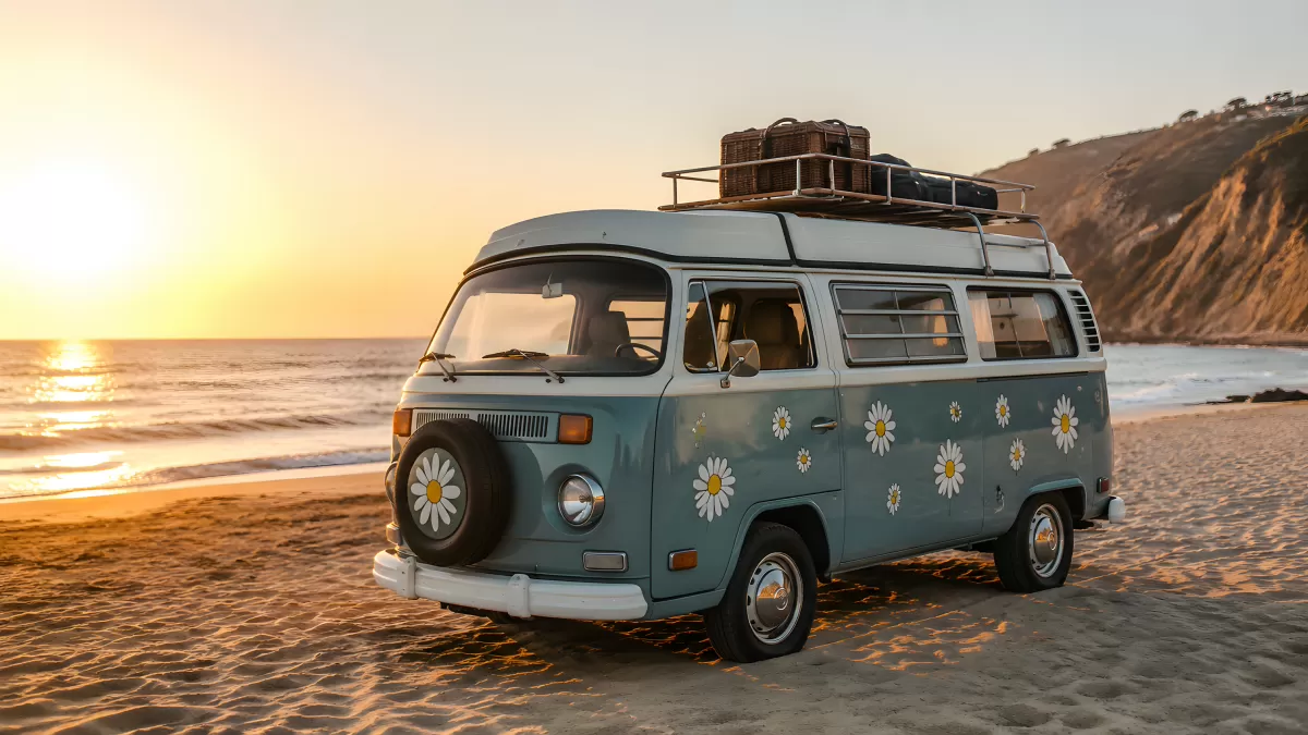 Retro VW-Bus mit Blumen am Strand bei Sonnenuntergang