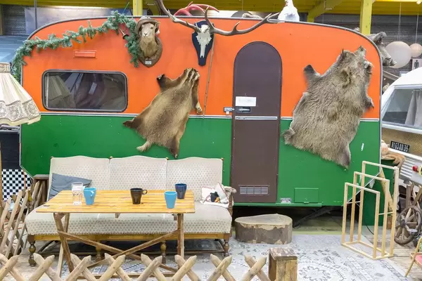 Retro-Wohnwagen mit Jagdreliquien, einer Sofa und einer Lampe im Vordergrund in BaseCamp Hostel in Bonn