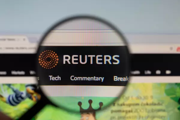Reuters logo on a computer screen with a magnifying glass