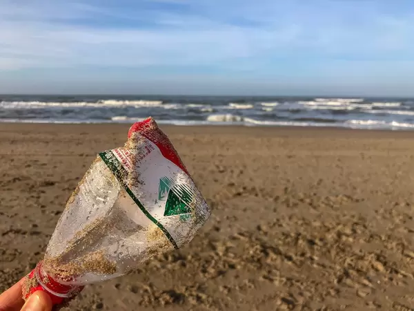 Reversed plastic bottle at the beach shows pollution