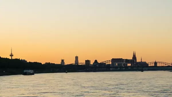 Rhein in Köln bei Sonnenuntergang. Kölner Dom in der Ferne