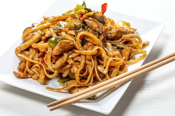 Rice noodles with chicken, mushrooms and vegetables close-up (Flip 2019)