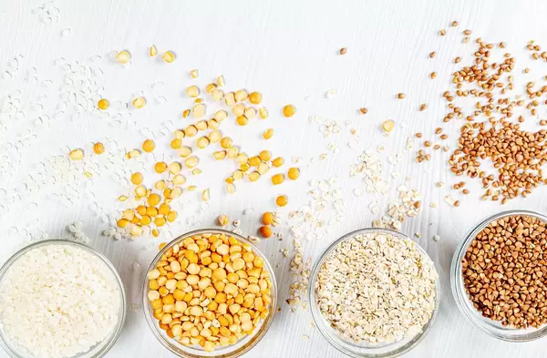 Rice, peas, oatmeal, buckwheat on a white background in glass bowls