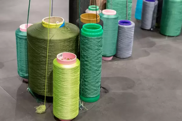 Riesige Spulen mit Faden für industrielle Verarbeitung und Produktion auf Boden