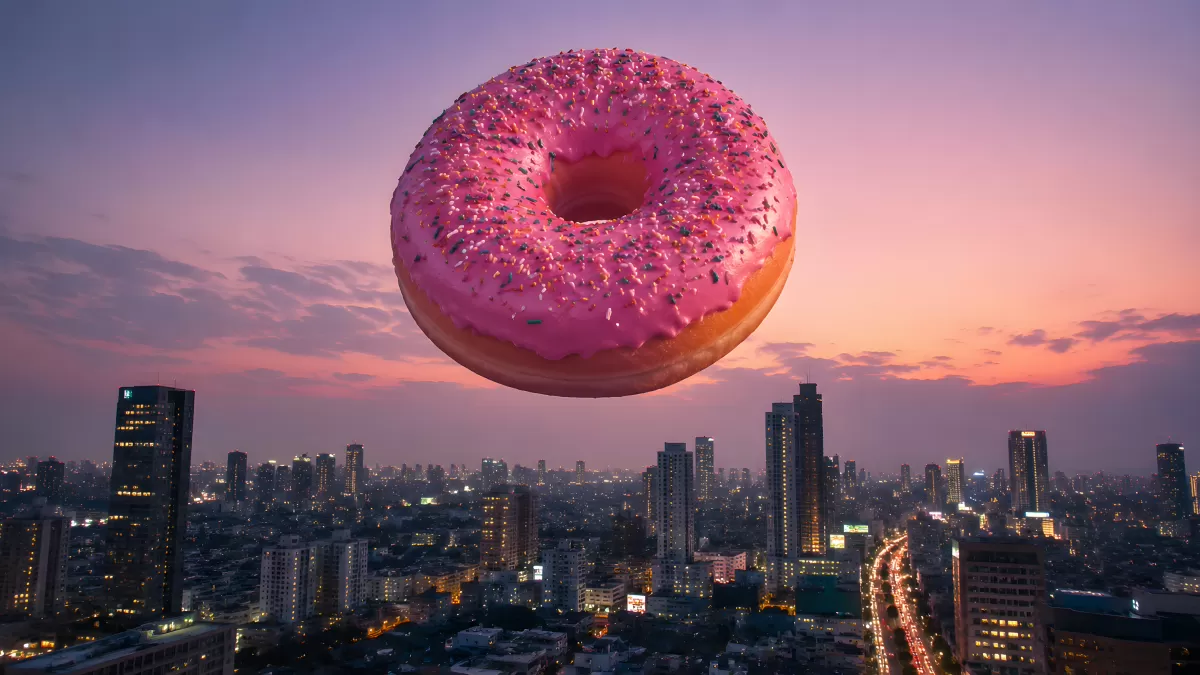 Riesiger pinker Donut schwebt über beleuchteter Stadtsilhouette